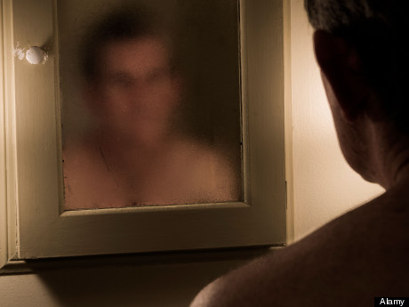 Man confronts his murky image in the mirror.